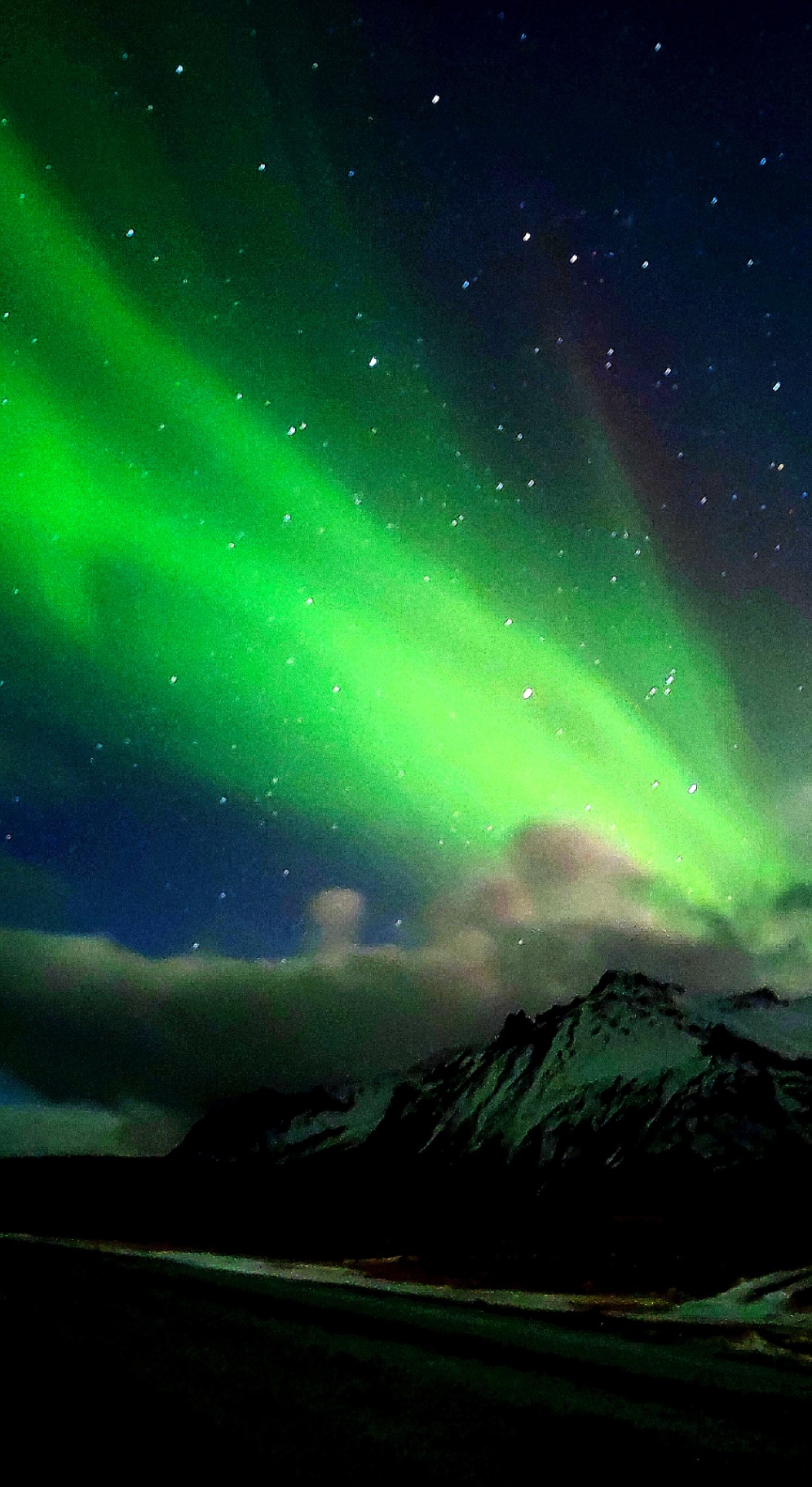 Aurora boreal sobre montaña nevada en el sur de Islandia