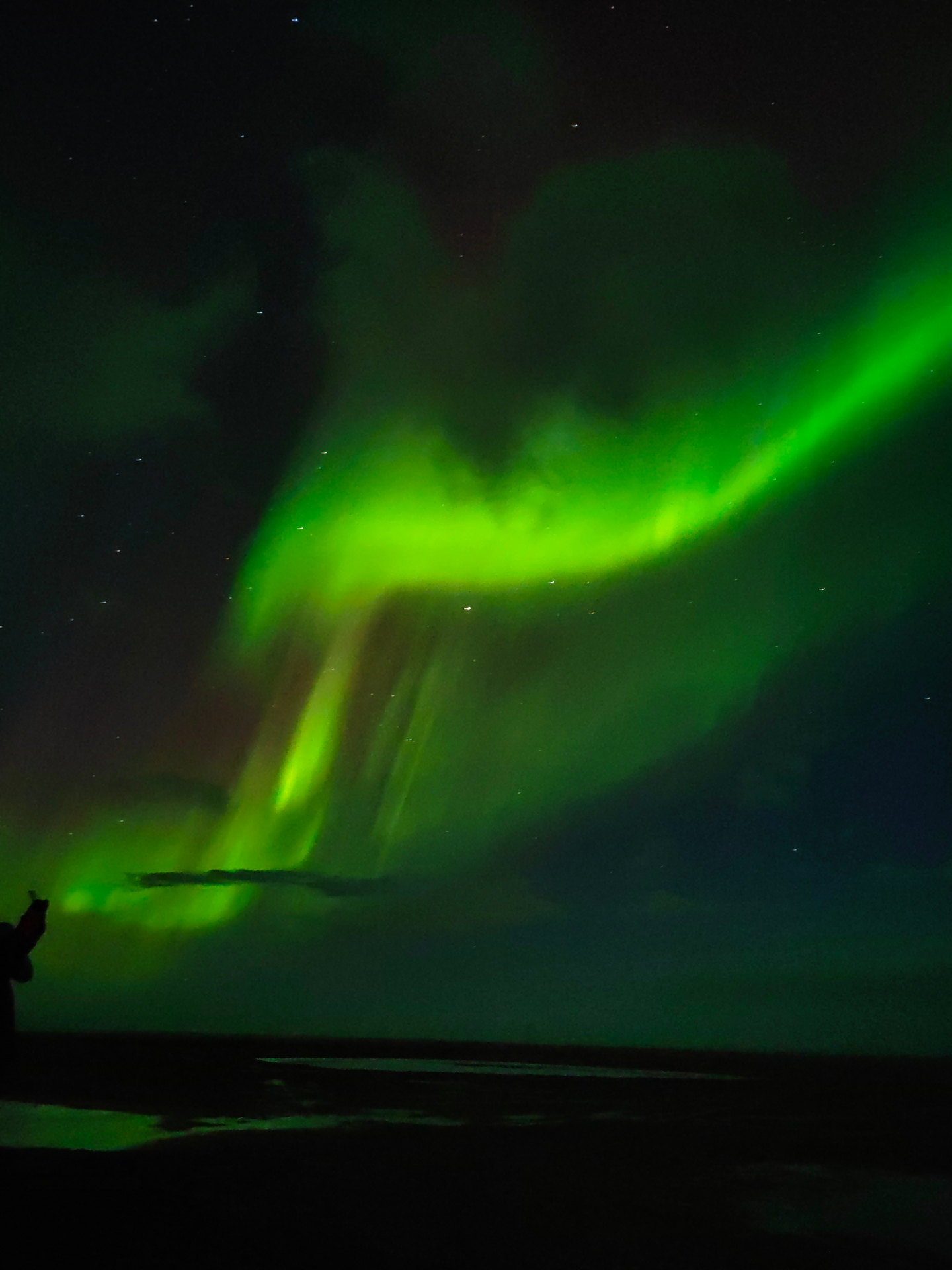 Aurora en cascada con silueta de viajero